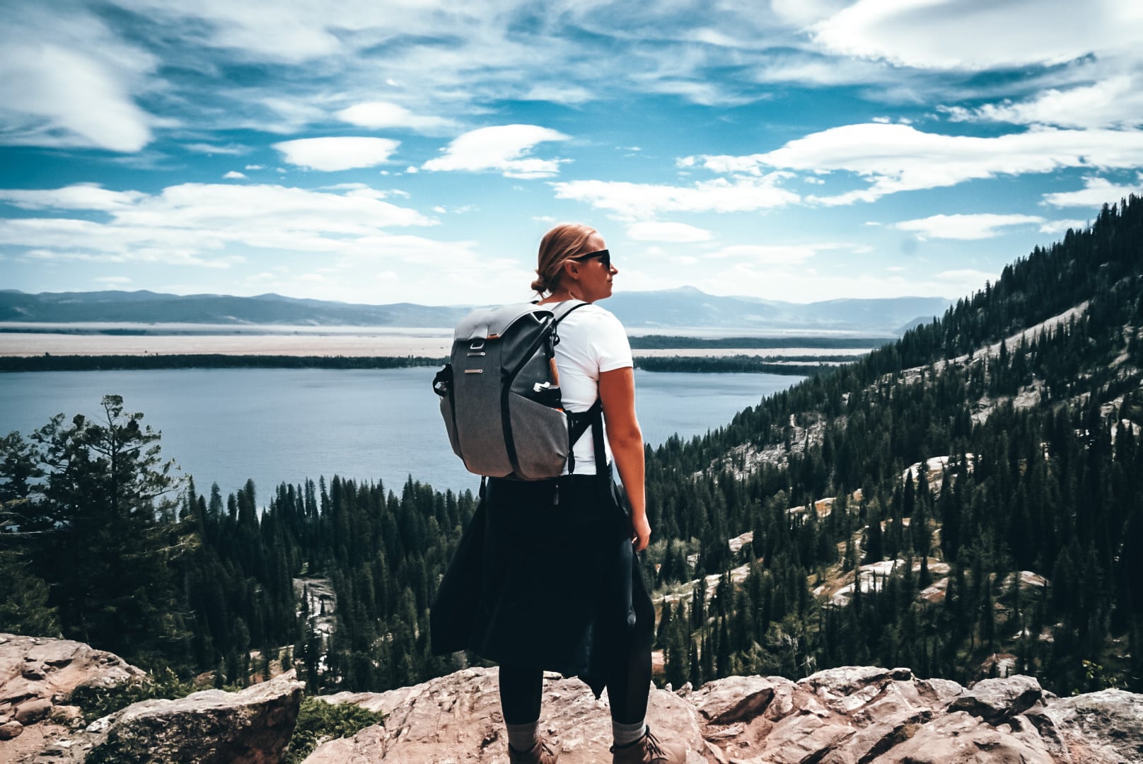 Hiking woman wearing backpack on Inspiration Point, Grand TEton