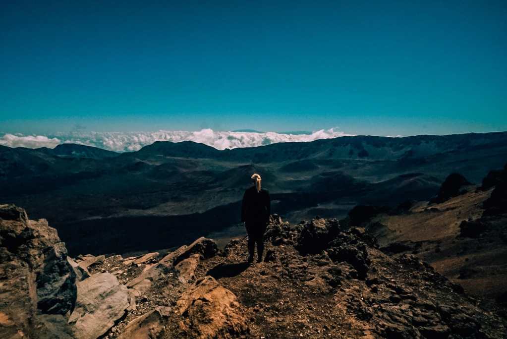 Woman standing atop the Sliding Sands trailhead before hiking into the Haleakala crater