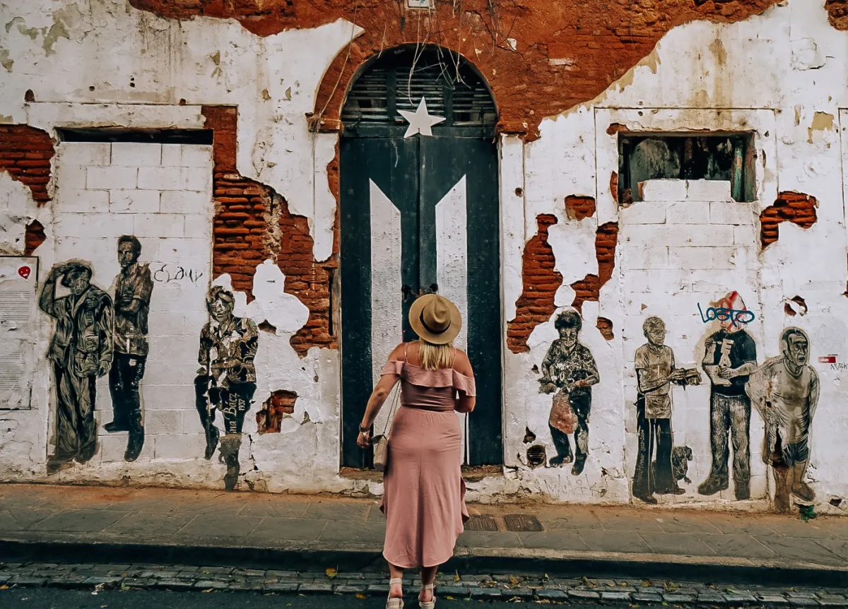 Woman standing in front of the Puerto Rican flag monument in Old San Juan