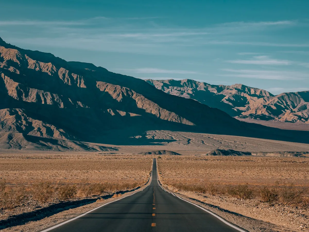Long straight road that leads into the mountains of Death Valley National Park