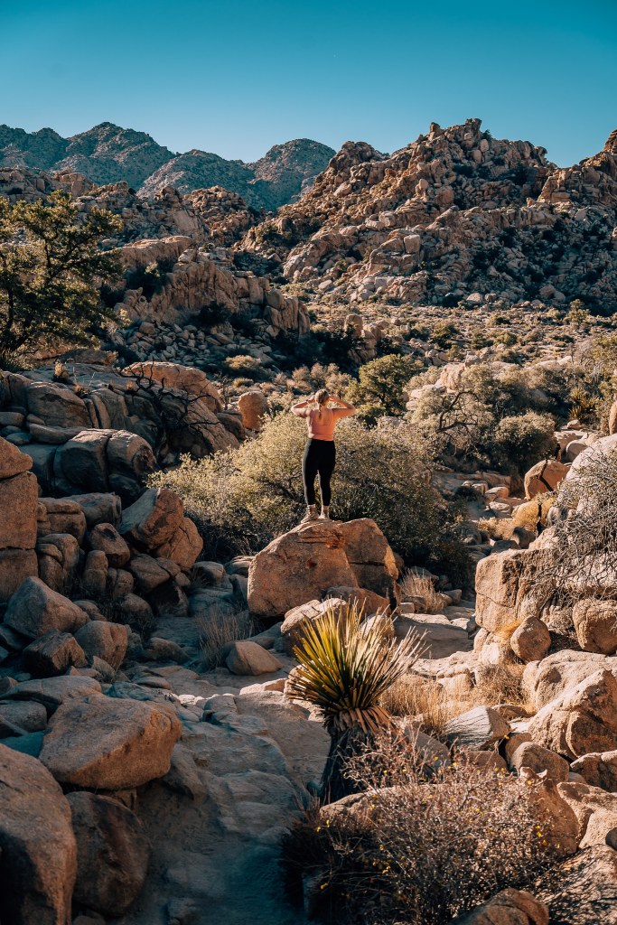 Woman standing among the rocks during a hike at Joshua Tree