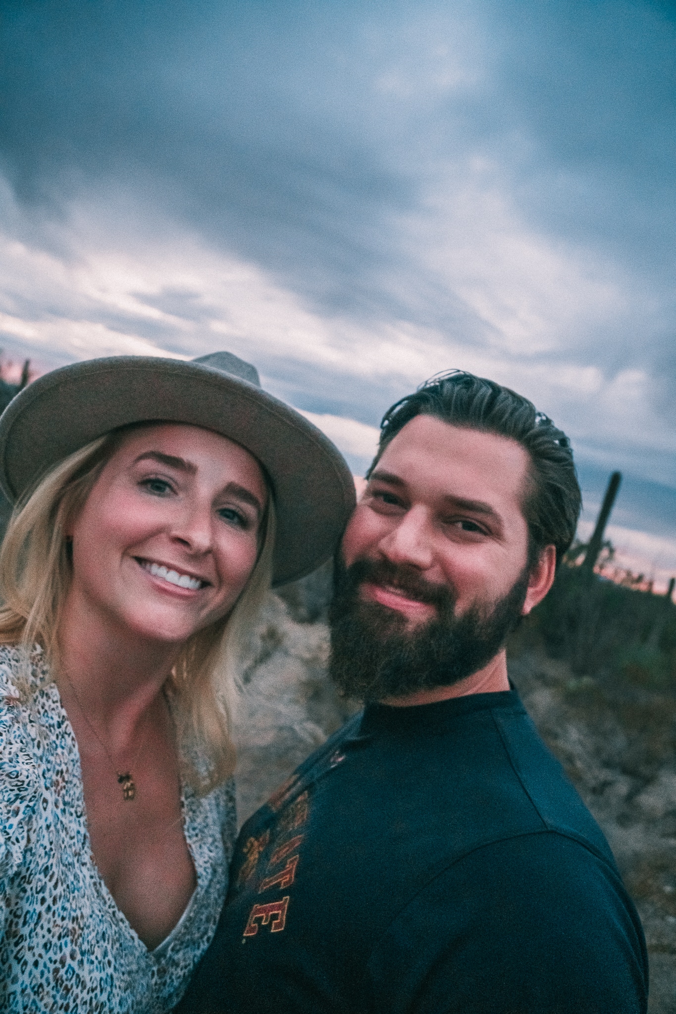 Man and woman smiling at camera in Saguaro National Park