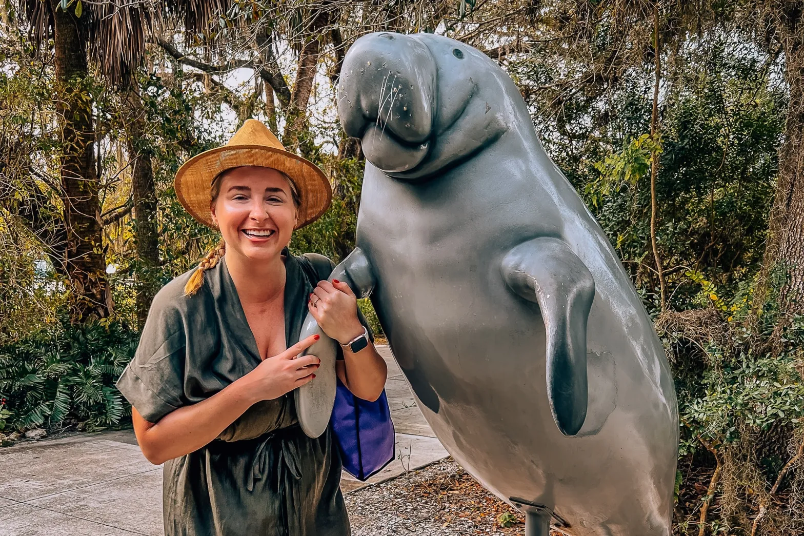 Woman standing next to a statue of a manatee at Manatee Park in Fort Myers