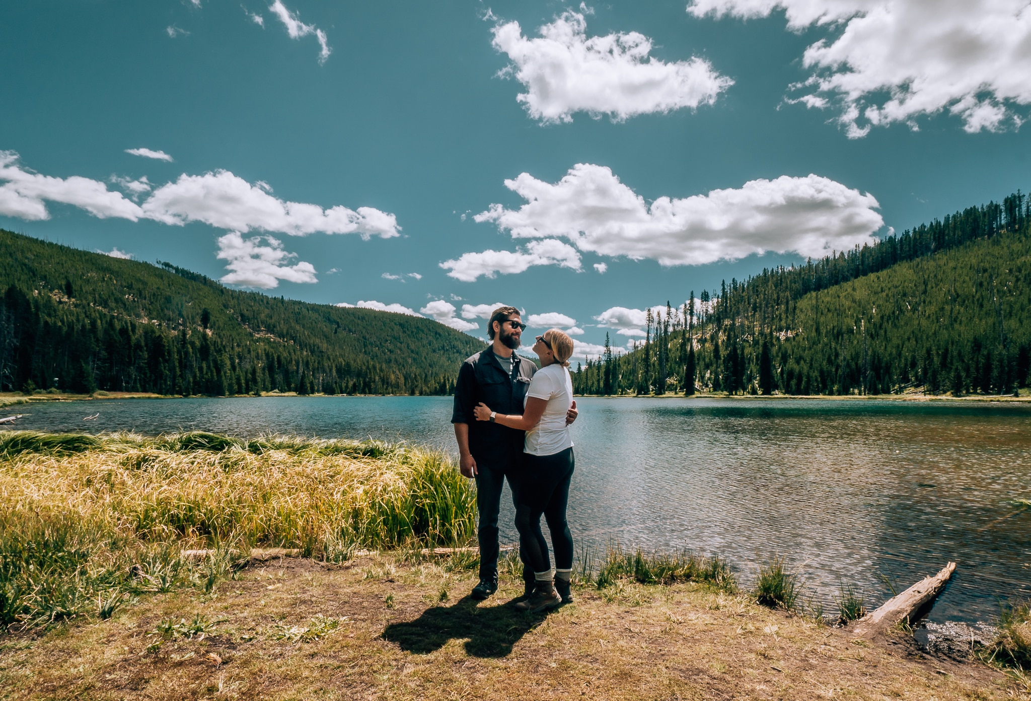 Man and woman standing in front of lake at Yellowstone National Park