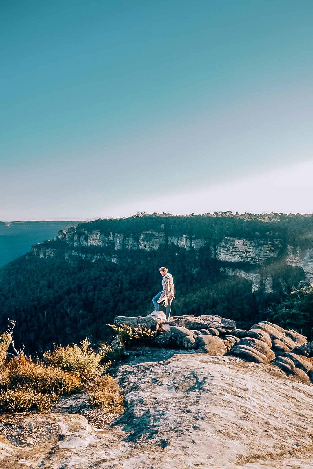 Woman standing on the rocks with the Blue Mountains of Australia in the background