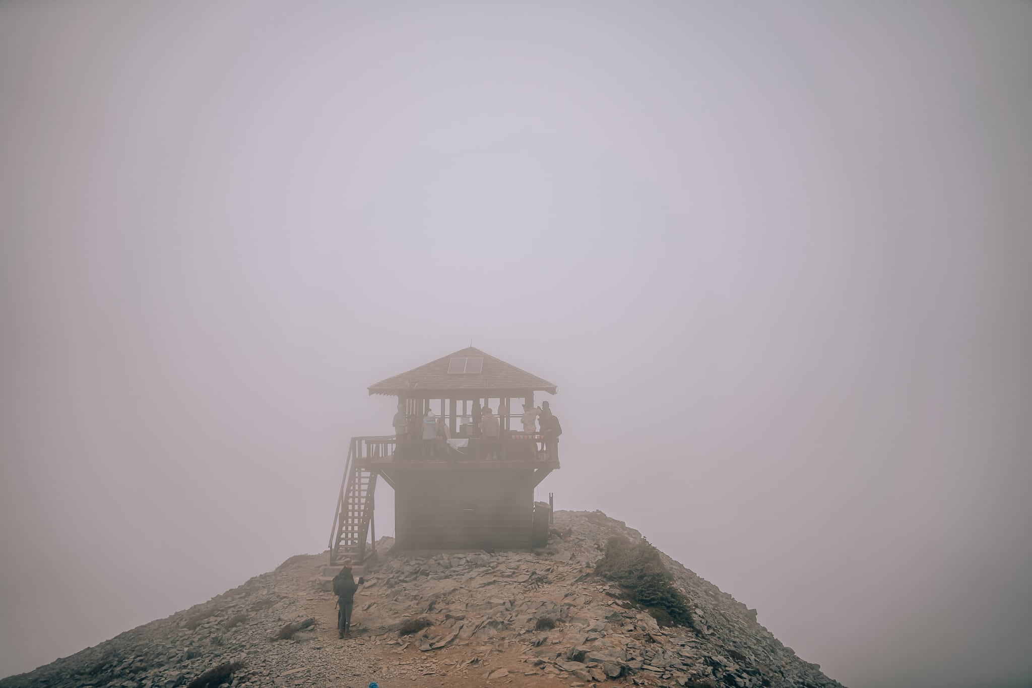 Fire tower surrounded fog and clouds with no view behind