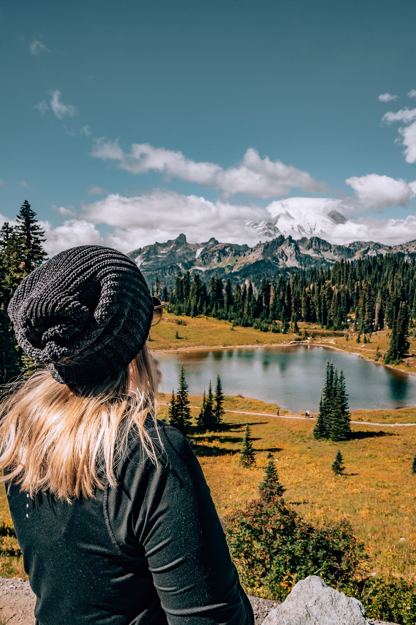 Woman looking out to Tipsoo Lake with the Cascade Mountains and Mount Rainier all in the background