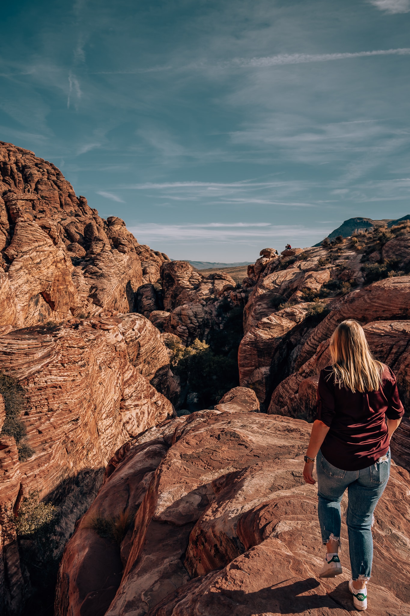 Woman walking on the red rocks into the canyon of Red Rock Canyon Conservation Area