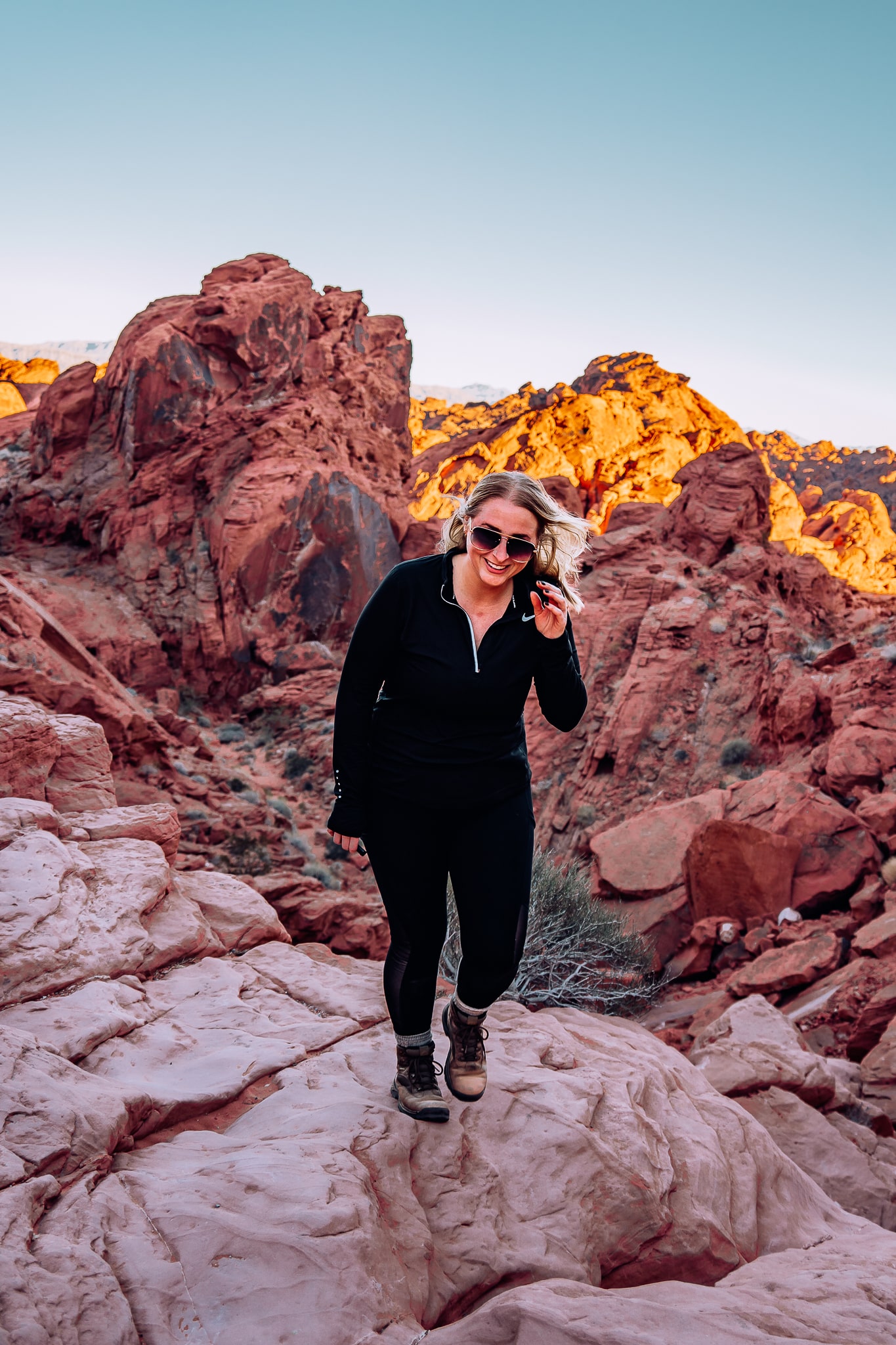 Woman standing on the ledge with a bunch of red rocks in the back in Valley of Fire State Park