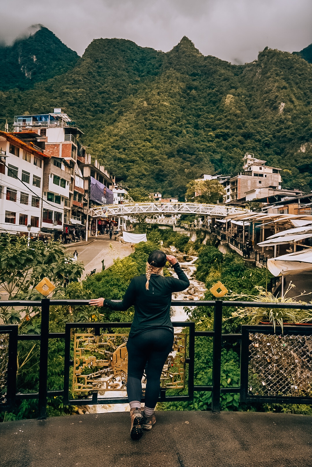 Woman standing in front of the view of the Peruvian mountain town of Aguas Calientes