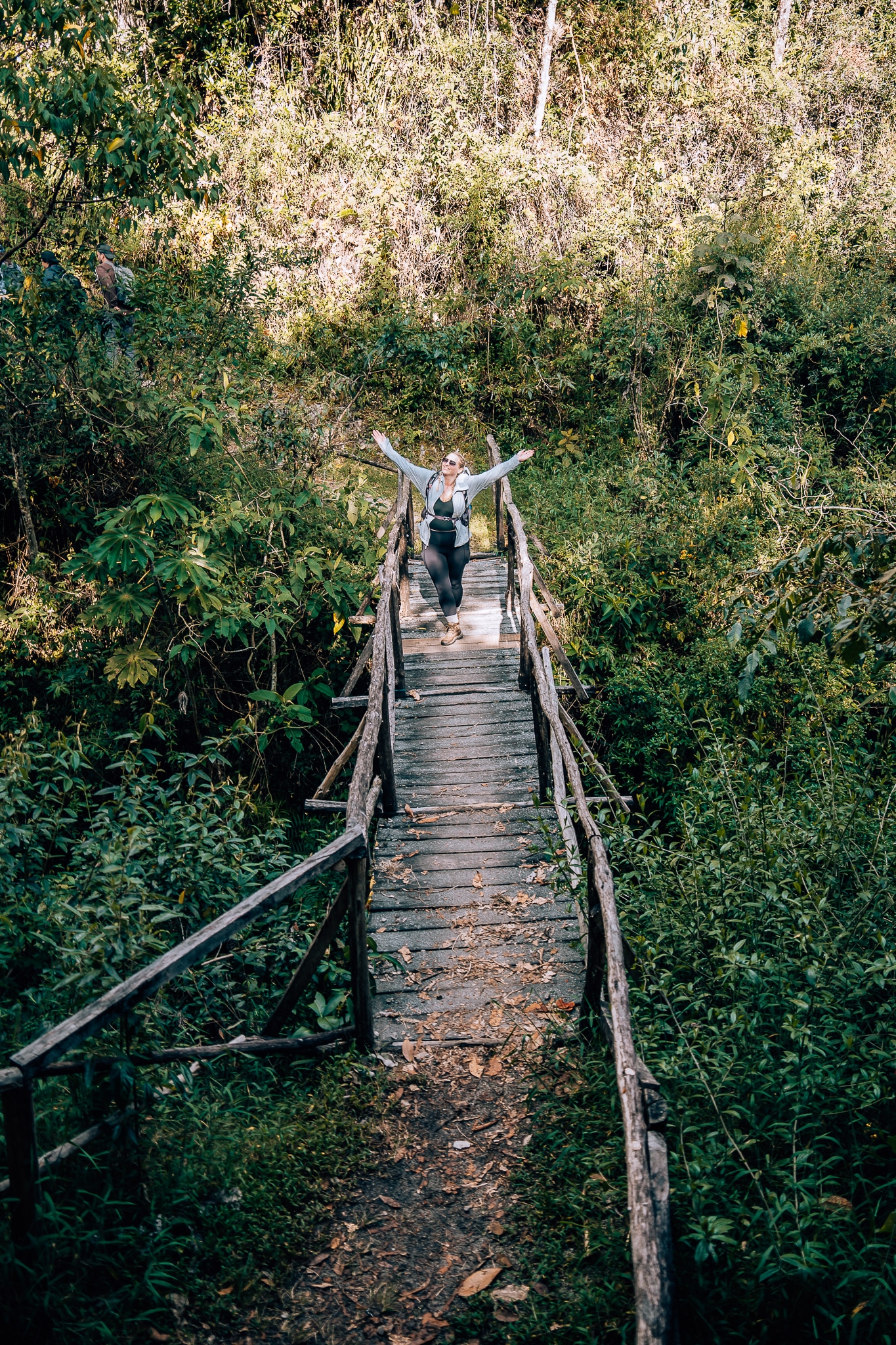 Woman standing on a bridge in the middle of the jungle