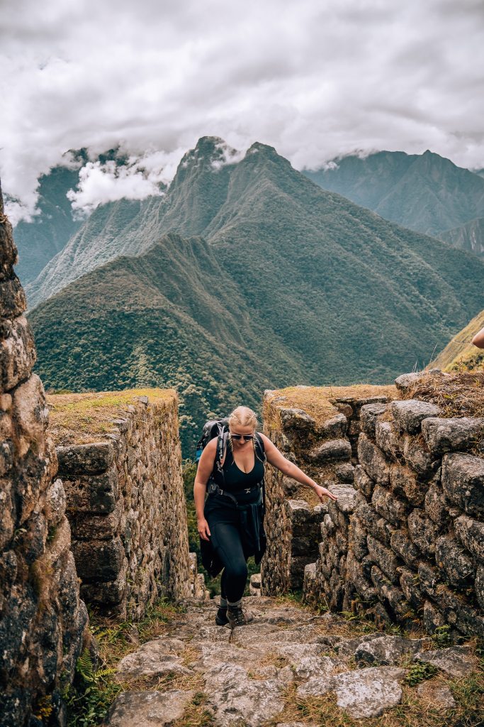 Woman walking up the stairs in Wiñay Wayna in the Inca Trail