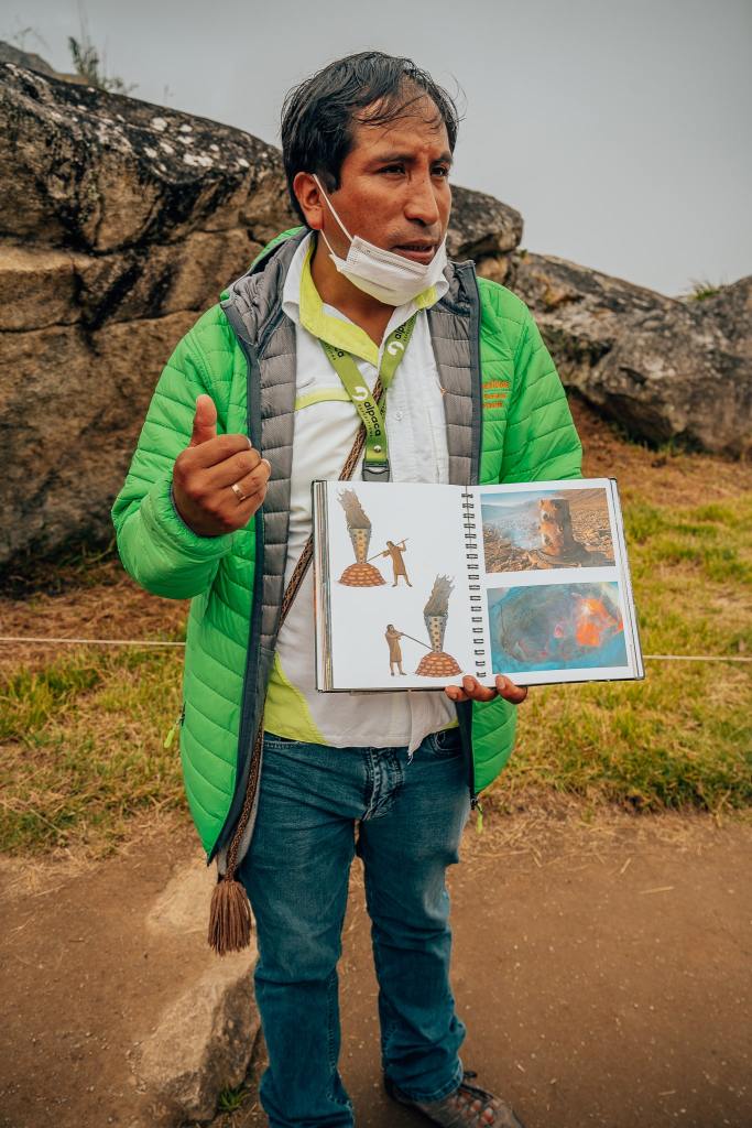 Guide at Alpaca Expeditions showing his book to his tourists at Machu Picchu