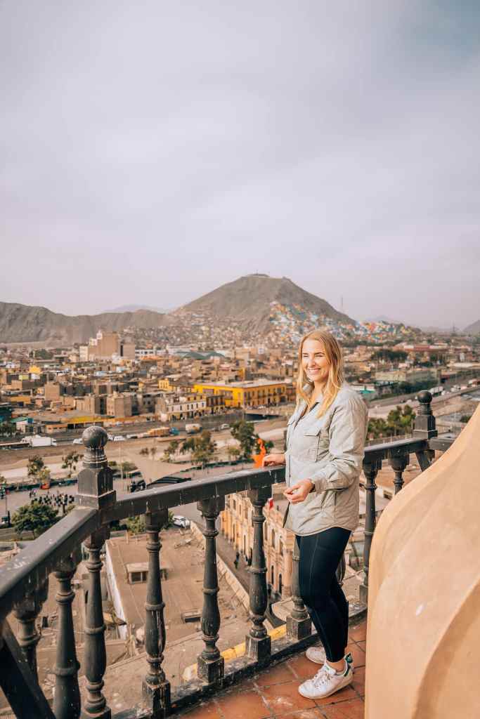 Woman standing on a balcony with the city of Lima in the background