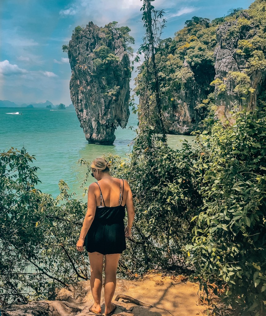 Woman looking out to James Bond Island in Thailand, a very thin but tall island that juts out of the water