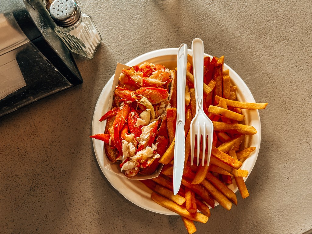 Lobster roll and fries with plastic knife and fork