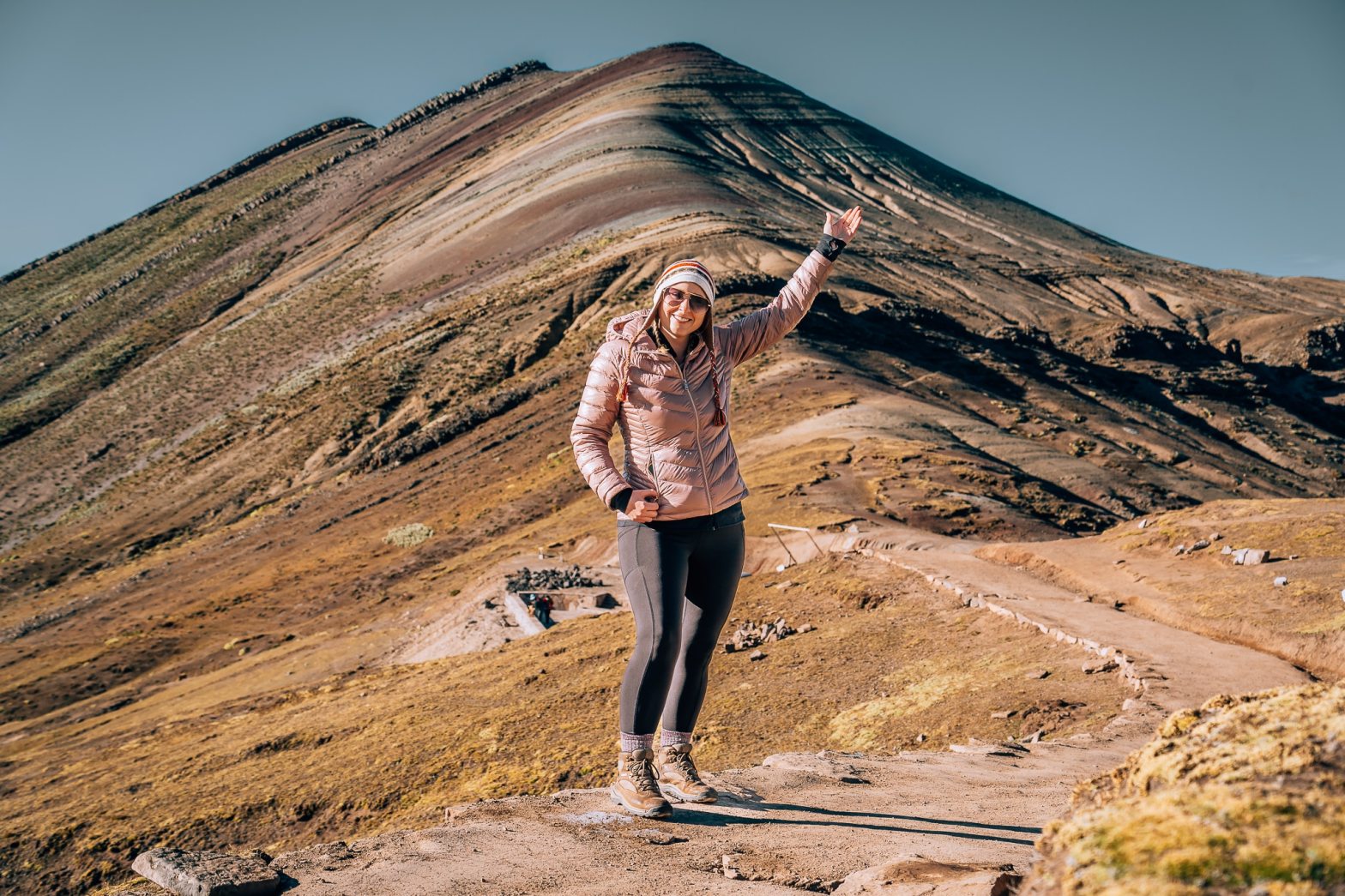 Woman standing in front of the main rainbow mountain at Palccoyo in Peru