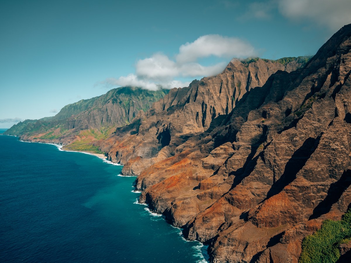 View of Kauai's famous NaPali Coast from in a helicopter, with the ocean off to the left and the coastline to the right