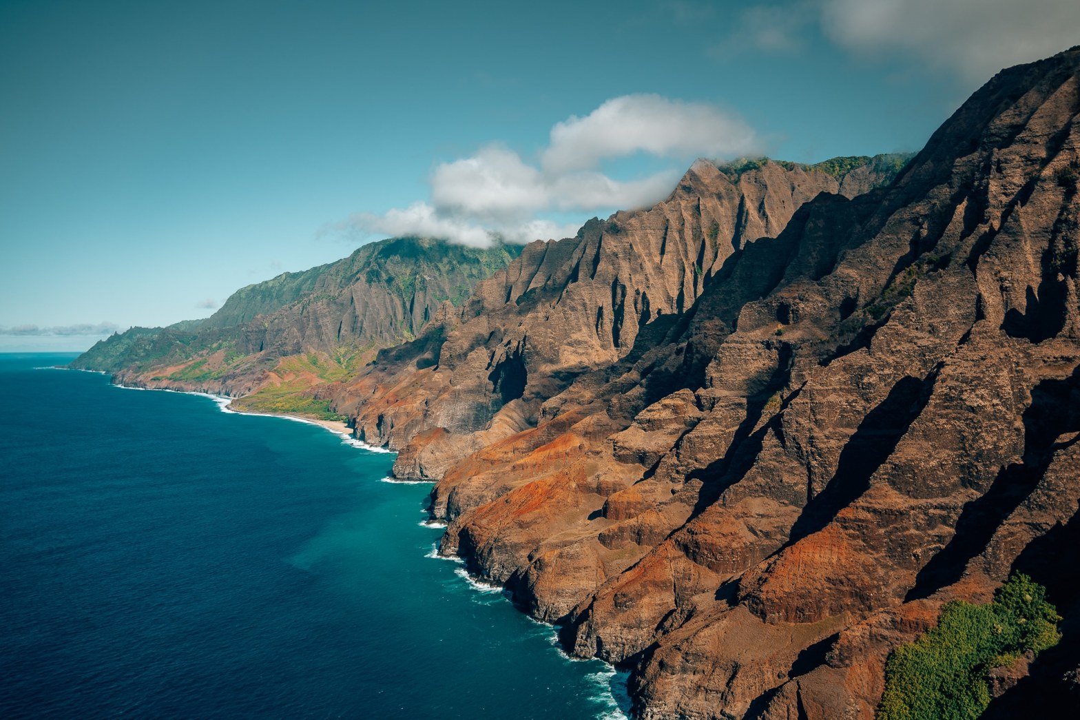 View of Kauai's famous NaPali Coast from in a helicopter, with the ocean off to the left and the coastline to the right