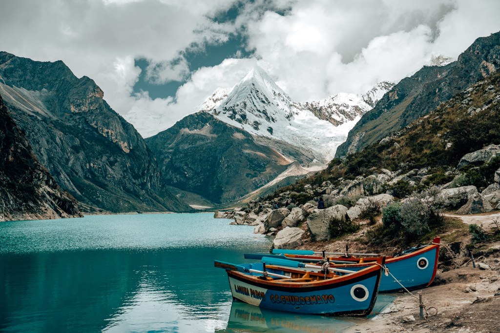 Boats sitting in Laguna Paron with the mountain in the background