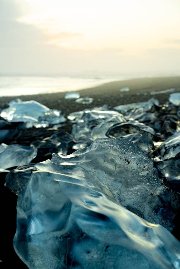 Up close of the glacier chunks on the black sand beach of Diamond Beach with the sun rising in the background