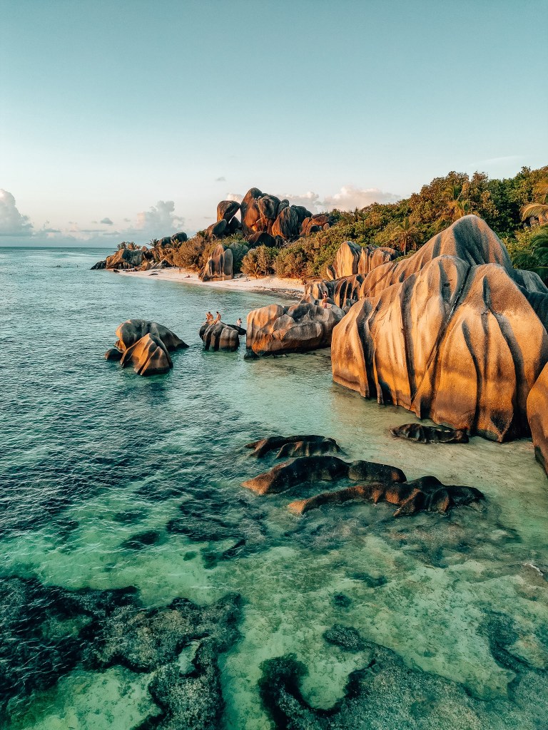 Shot from above of the famous Anse Source d'Argent in La Digue, Seychelles with the giant boulders glowing in the sunset