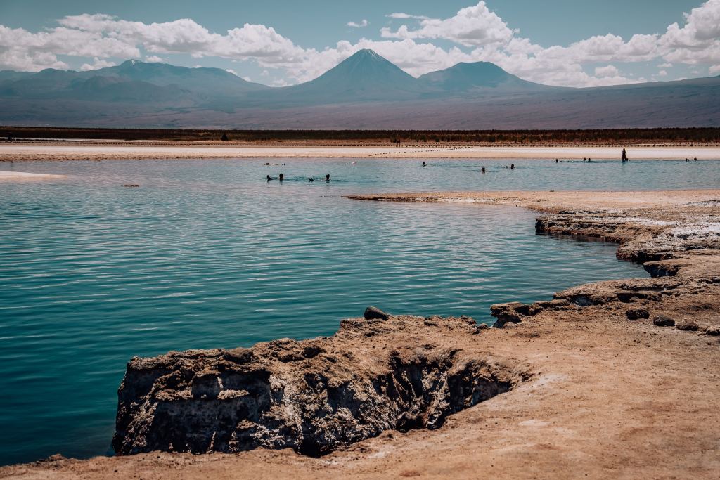 Laguna Piedra, a salt lagoon in the foreground where the mountain range surrounding the Atacama Desert is in the background
