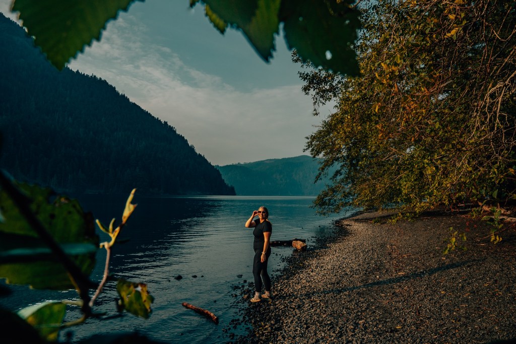Woman standing along the beach at Lake Crescent at Olympic National Park
