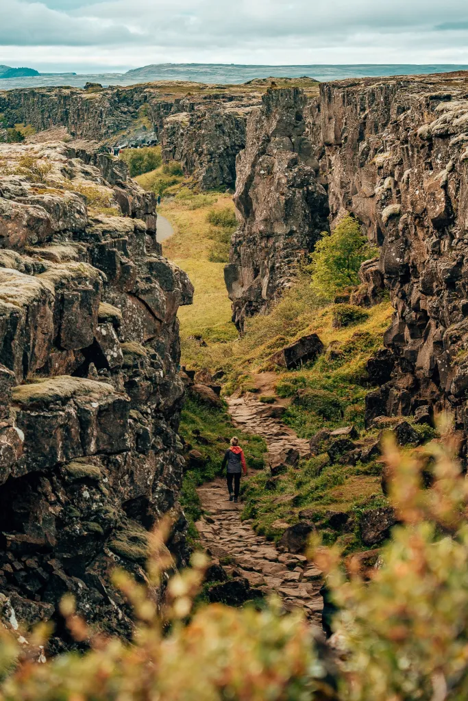 View of woman standing in the Walk of Death (in the middle of the tectonic plates) in Iceland's Thingvellir National Park